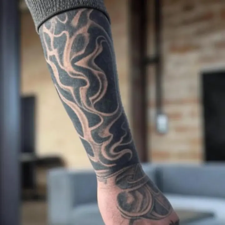 Részlet egy urbánus tetoválásról egy karon, sötét, városi hangulatú stílusban